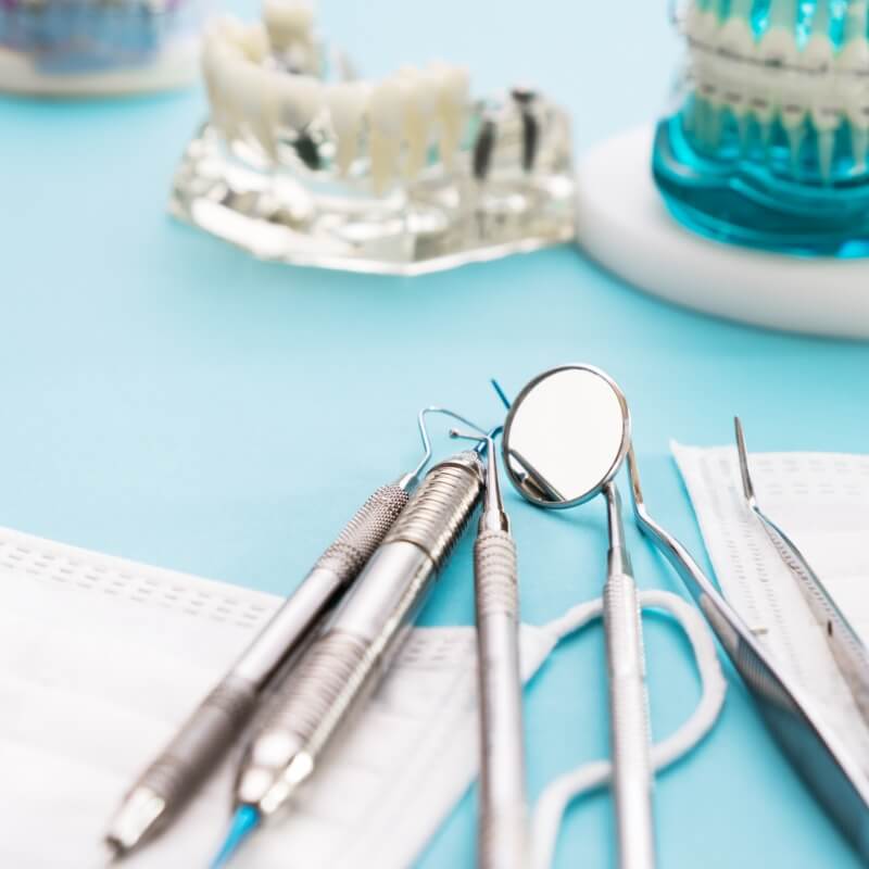 Zahnarztbesteck und Gebiss-Modelle liegen am Tisch